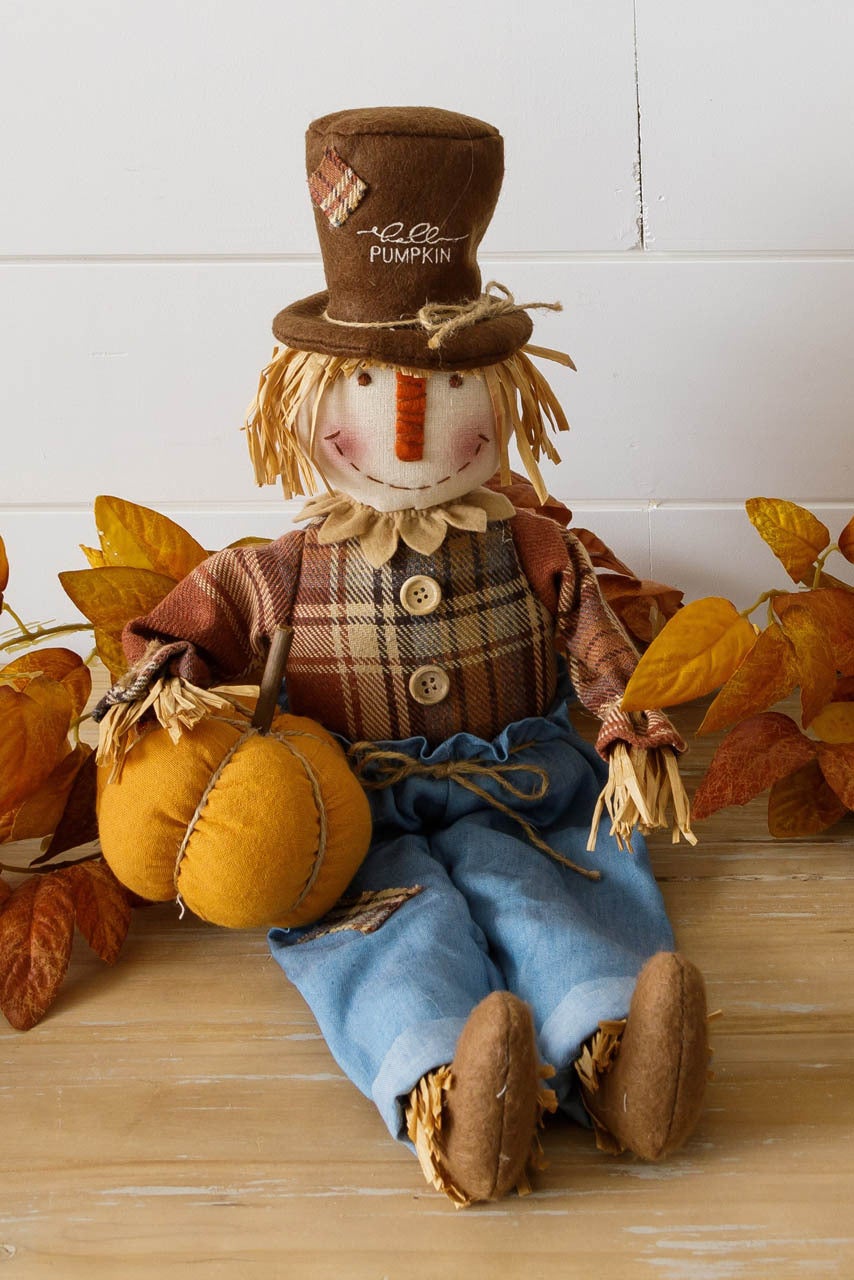 Scarecrow Sitter Holding Pumpkin - fall | The Wizard Gift Corporation